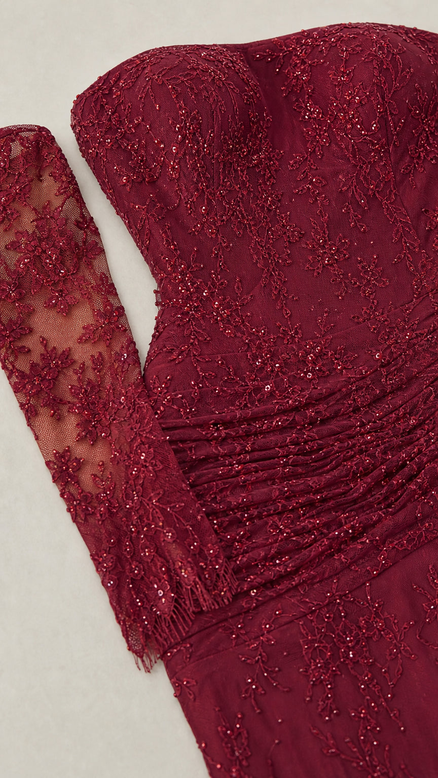 Close-up detail of burgundy beaded embroidered lace and ruched waist fabric