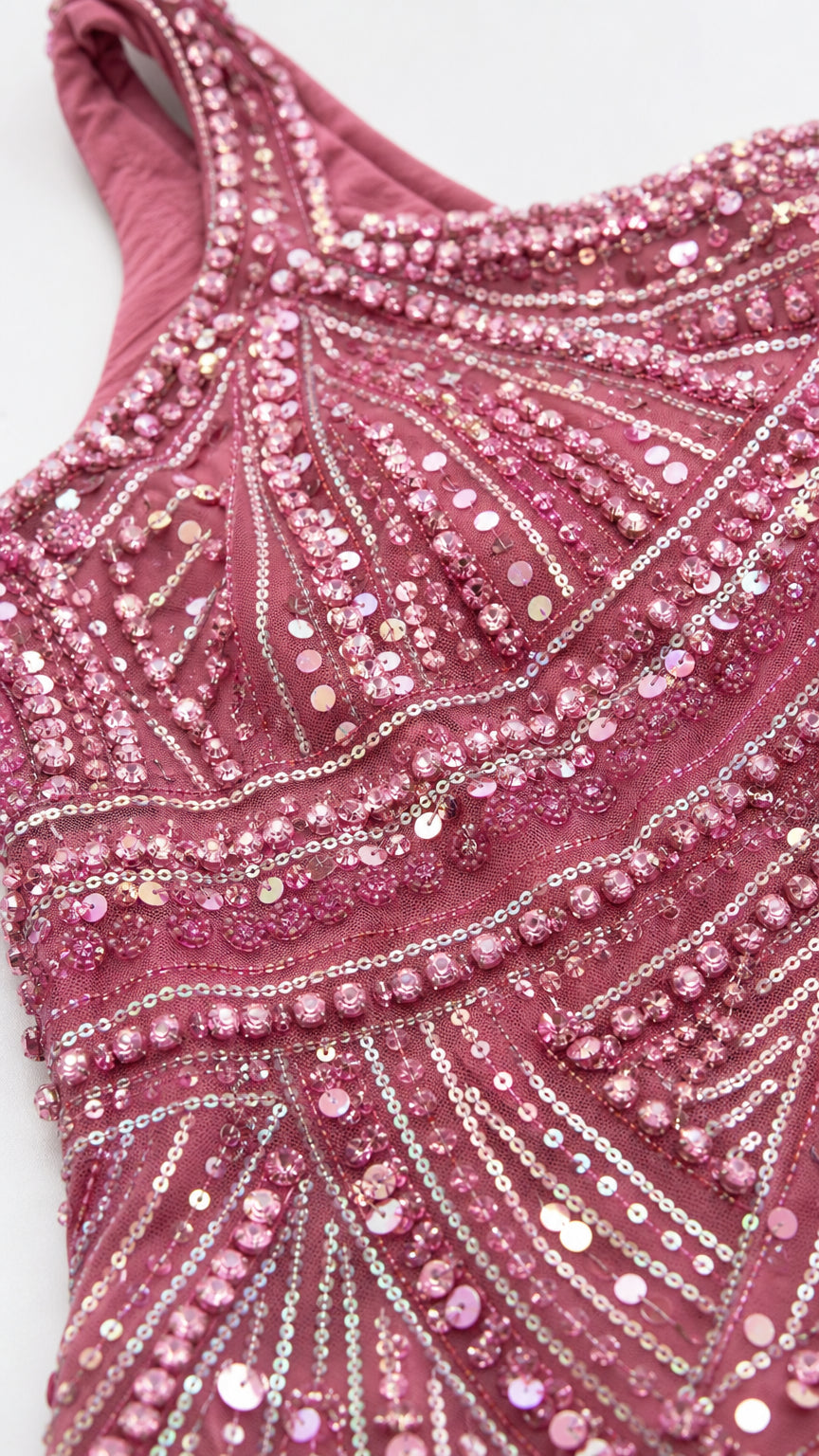 Close-up detail of intricate bead and sequin embroidery on mauve pink fabric