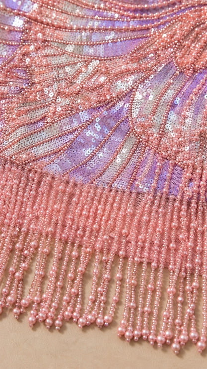 Close-up detail of swirl sequin embroidery and beaded fringe tassel hem