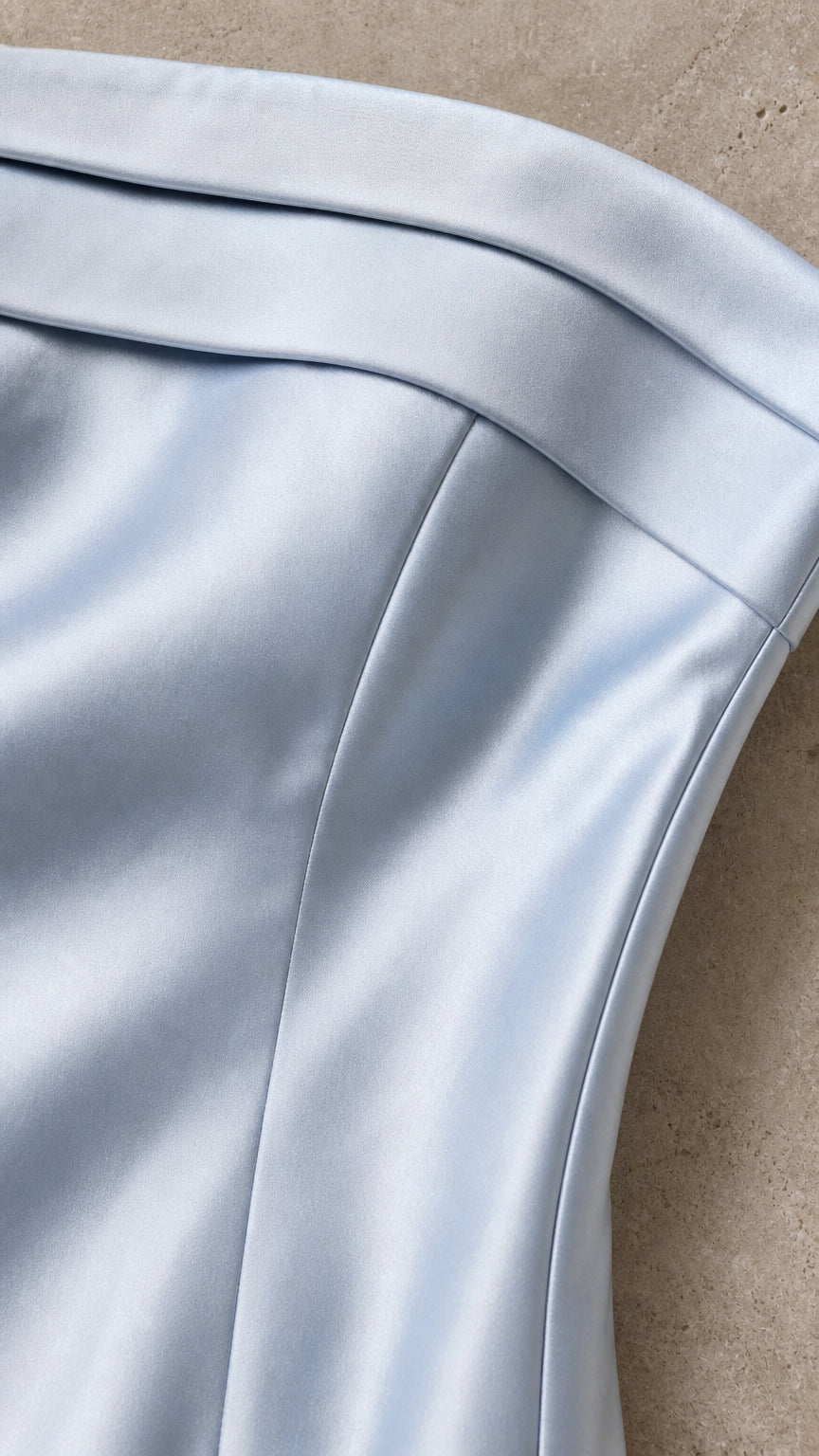 Close-up detail of pleated folded bust construction on light blue satin fabric