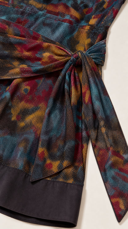 Close-up detail of side knot sash, abstract textured print, and black contrast hem