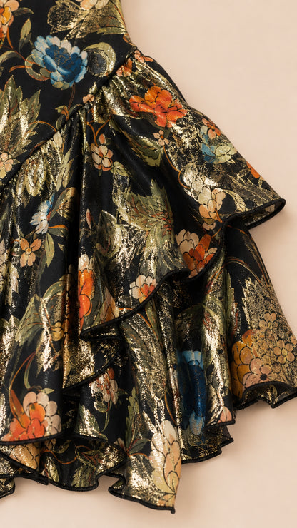 Close-up detail of black metallic floral jacquard fabric and layered ruffle hem