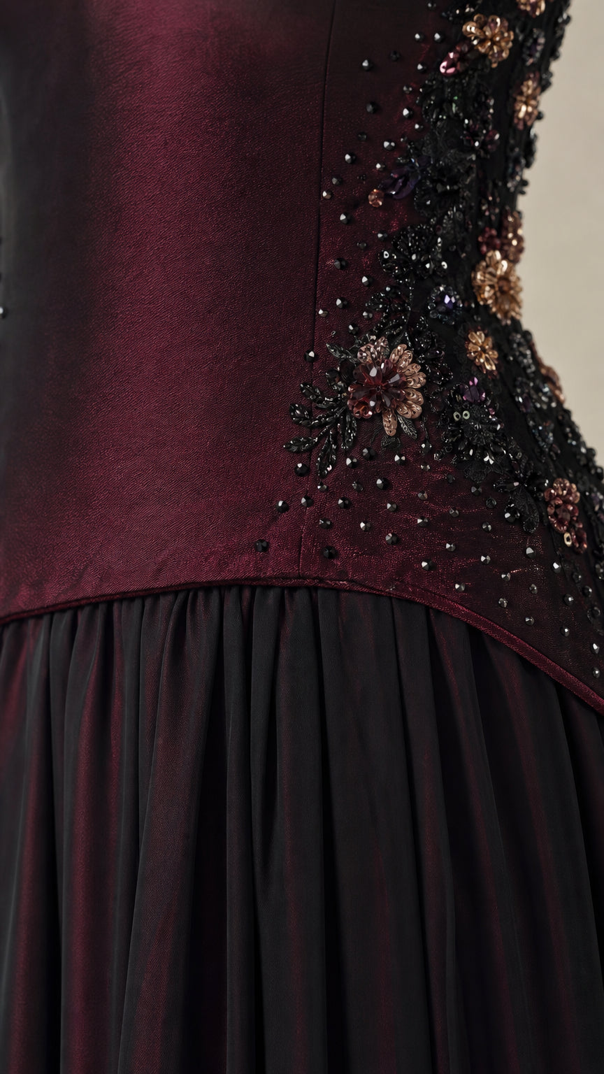 Close-up detail of intricate floral beadwork on burgundy satin bodice