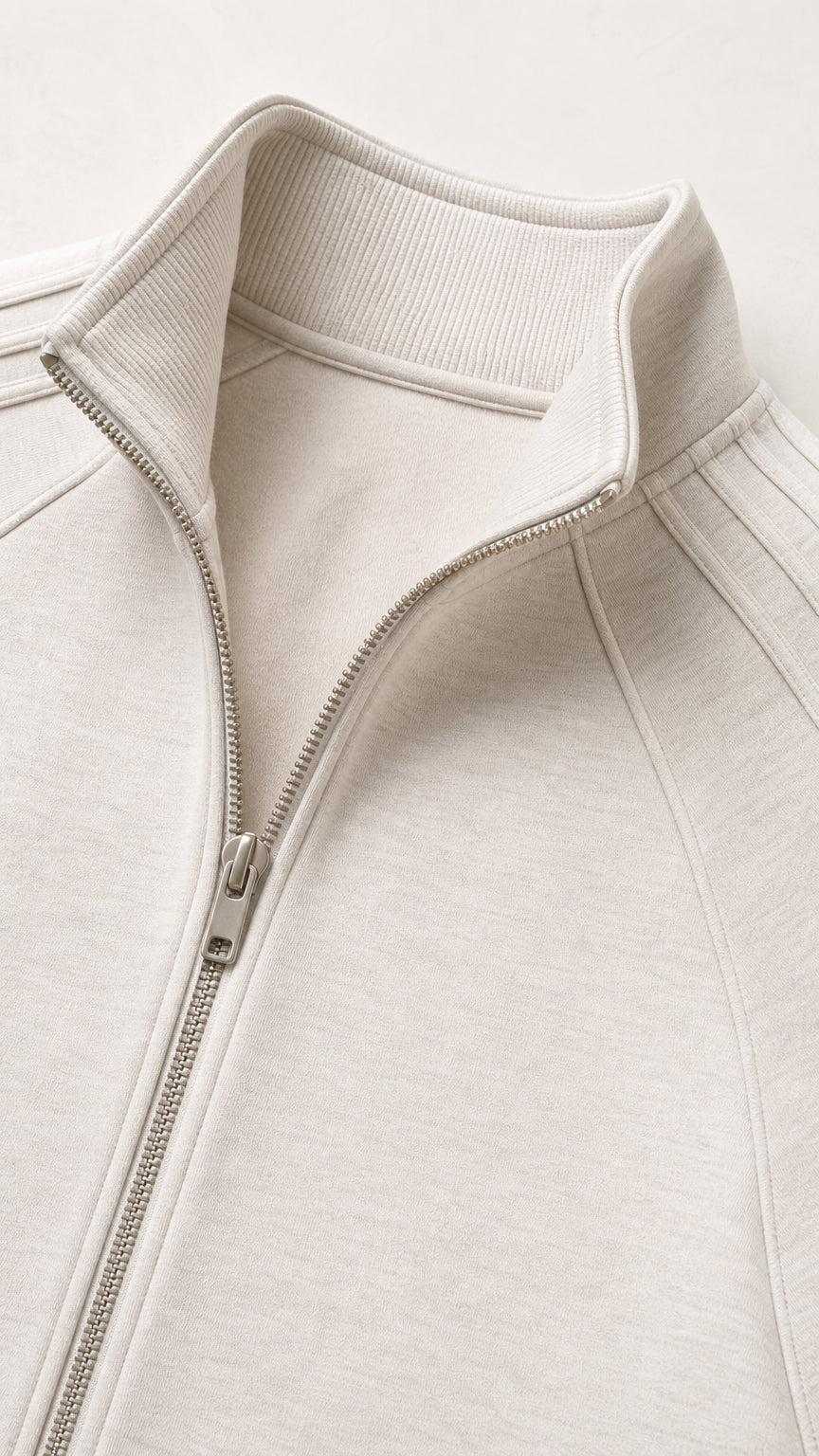 Close-up detail of ribbed stand collar and front zipper on beige top