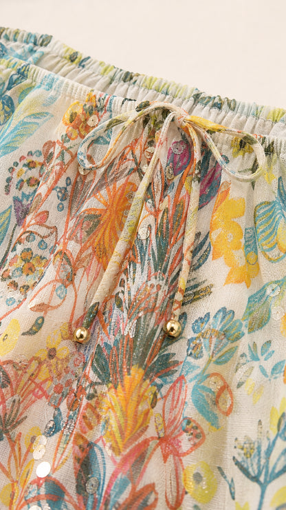 Close-up detail of neckline drawstring with gold beads and lightweight floral fabric texture