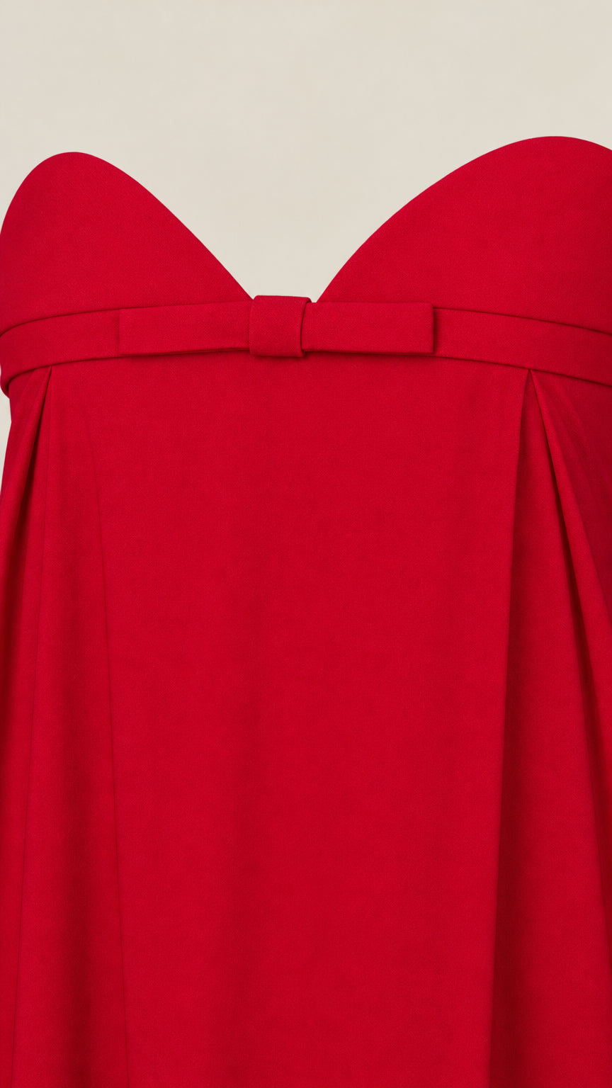 Close-up detail of sweetheart neckline and tailored bow accent on red maxi dress