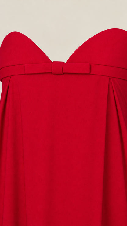 Close-up detail of sweetheart neckline and tailored bow accent on red maxi dress