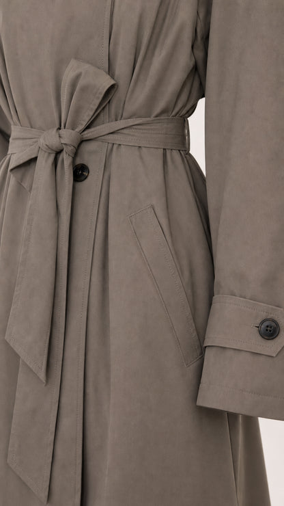 Close-up detail of waist belt tie, side pocket, and cuff button