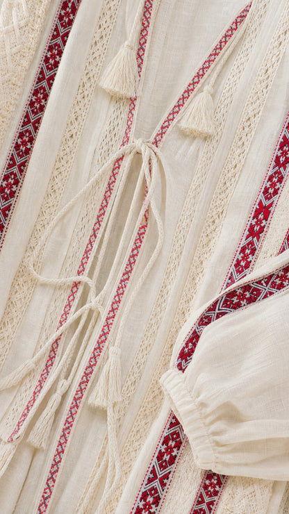 Close-up detail of textured woven fabric, burgundy embroidery, and tassel ties