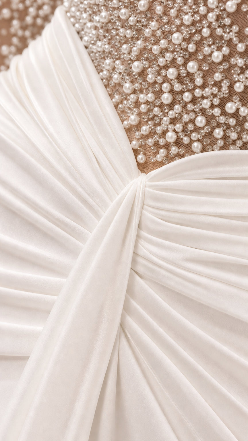 Close-up detail of pearl embellishments and ruched gathered waist on gown