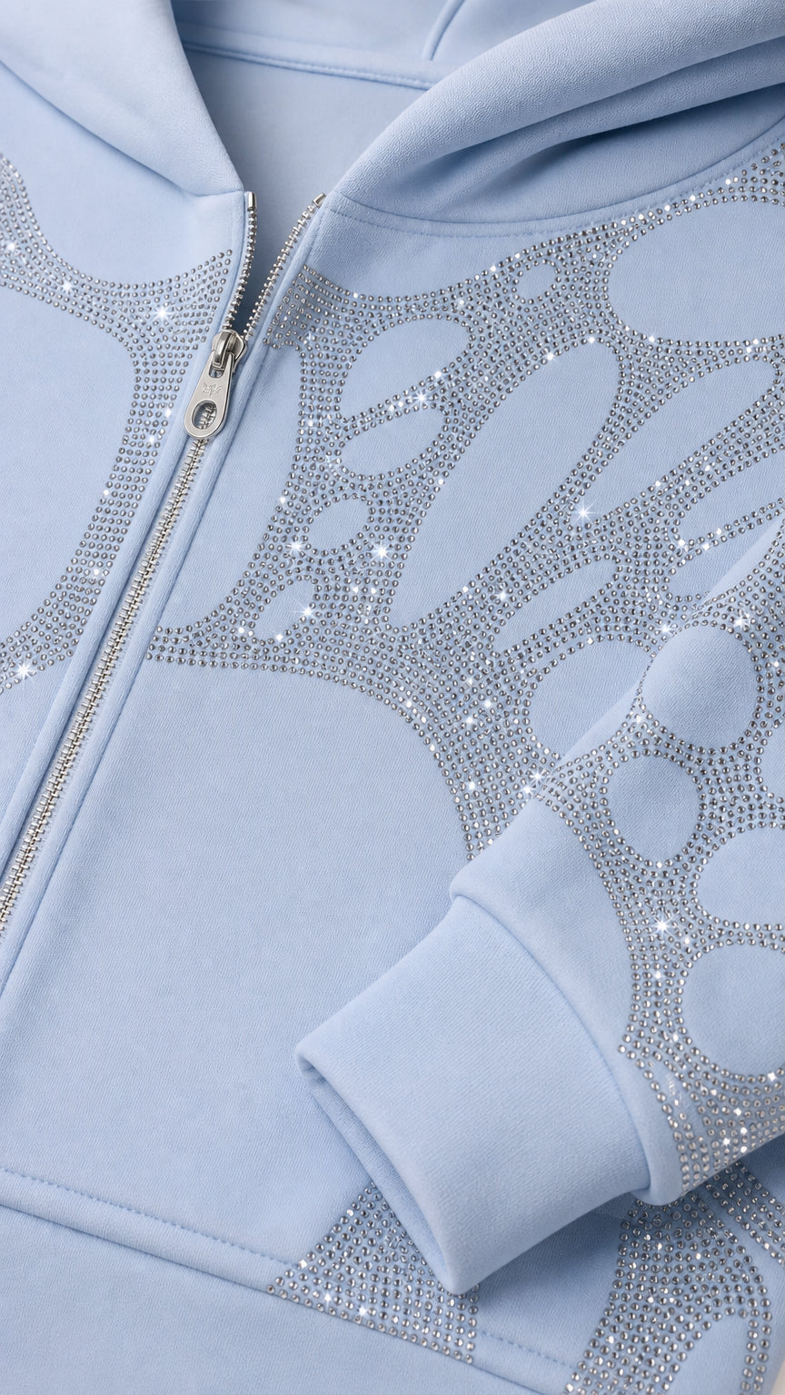 Close-up detail of rhinestone pattern and metal zipper on Light Blue cropped hoodie