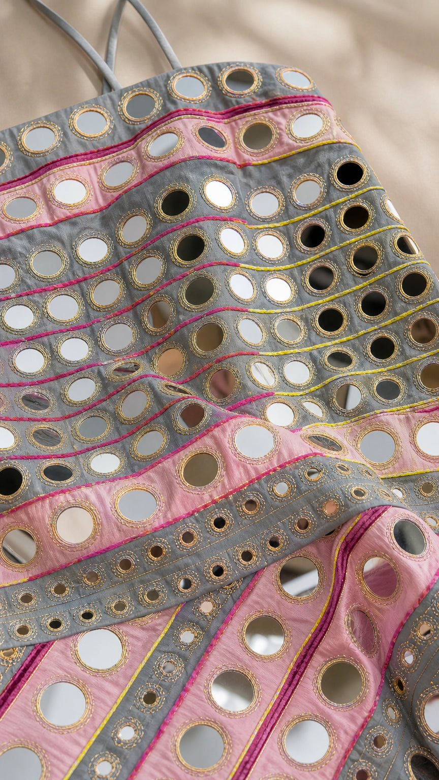 Close up texture detail of mirror discs and metallic embroidery on fabric