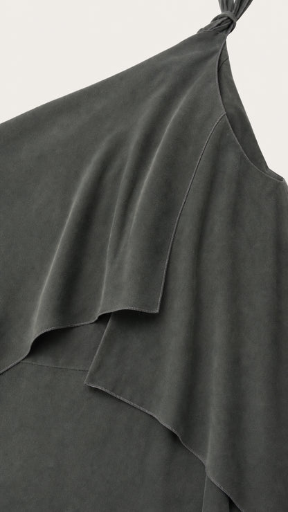 Close-up detail of the smooth matte draped fabric and clean edge hemline