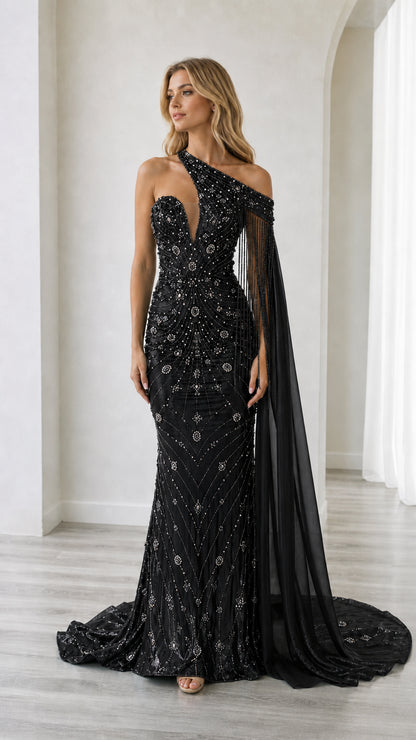 Front full-length view of the black beaded one-shoulder formal evening dress with sheer cape