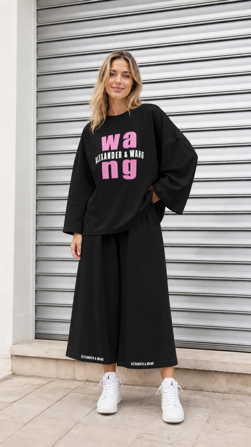 Model wearing black graphic sweatshirt and wide-leg matching lounge pants set