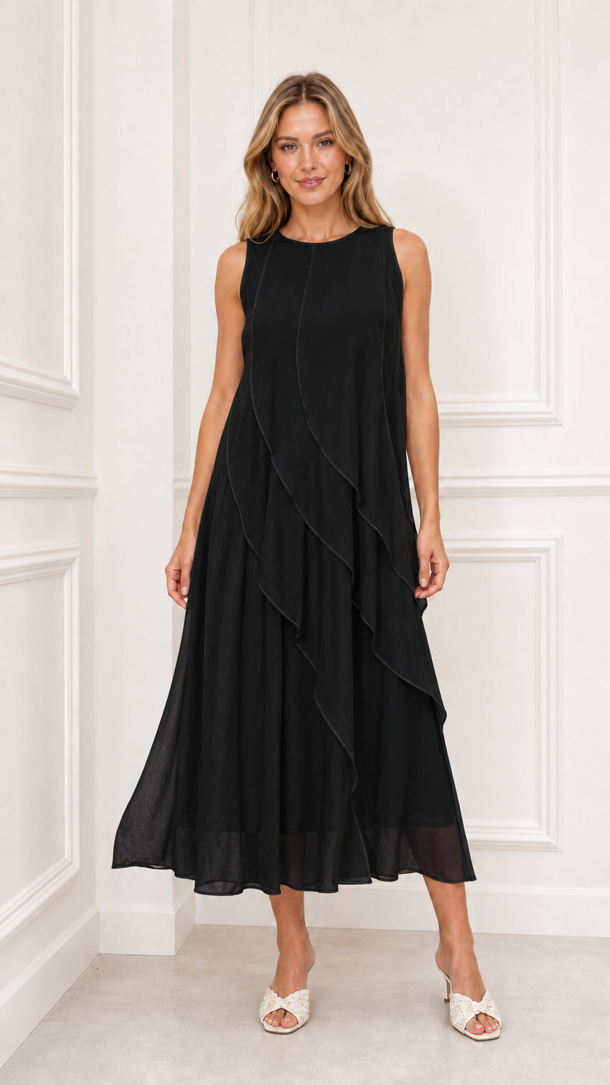 Model wearing black sleeveless tiered chiffon midi dress