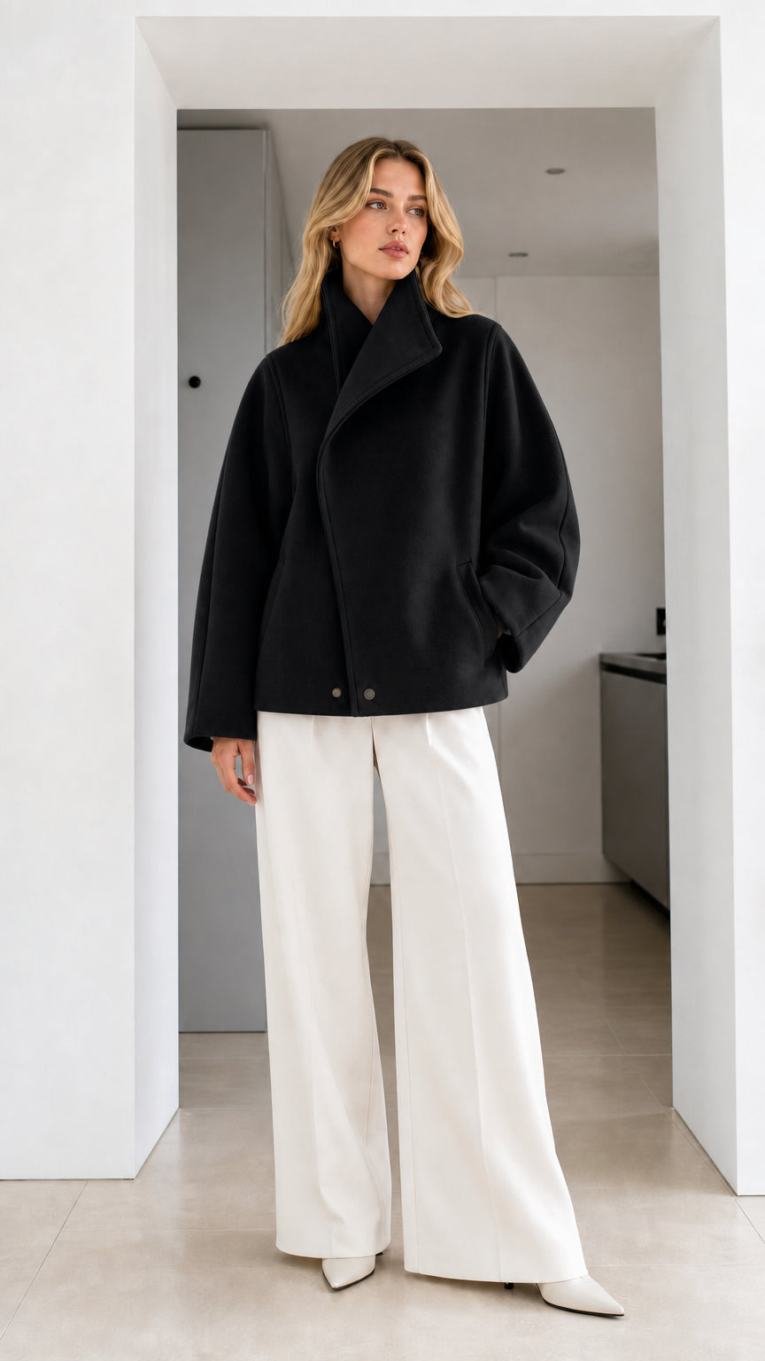 Full-length view of model wearing black high collar short wrap coat