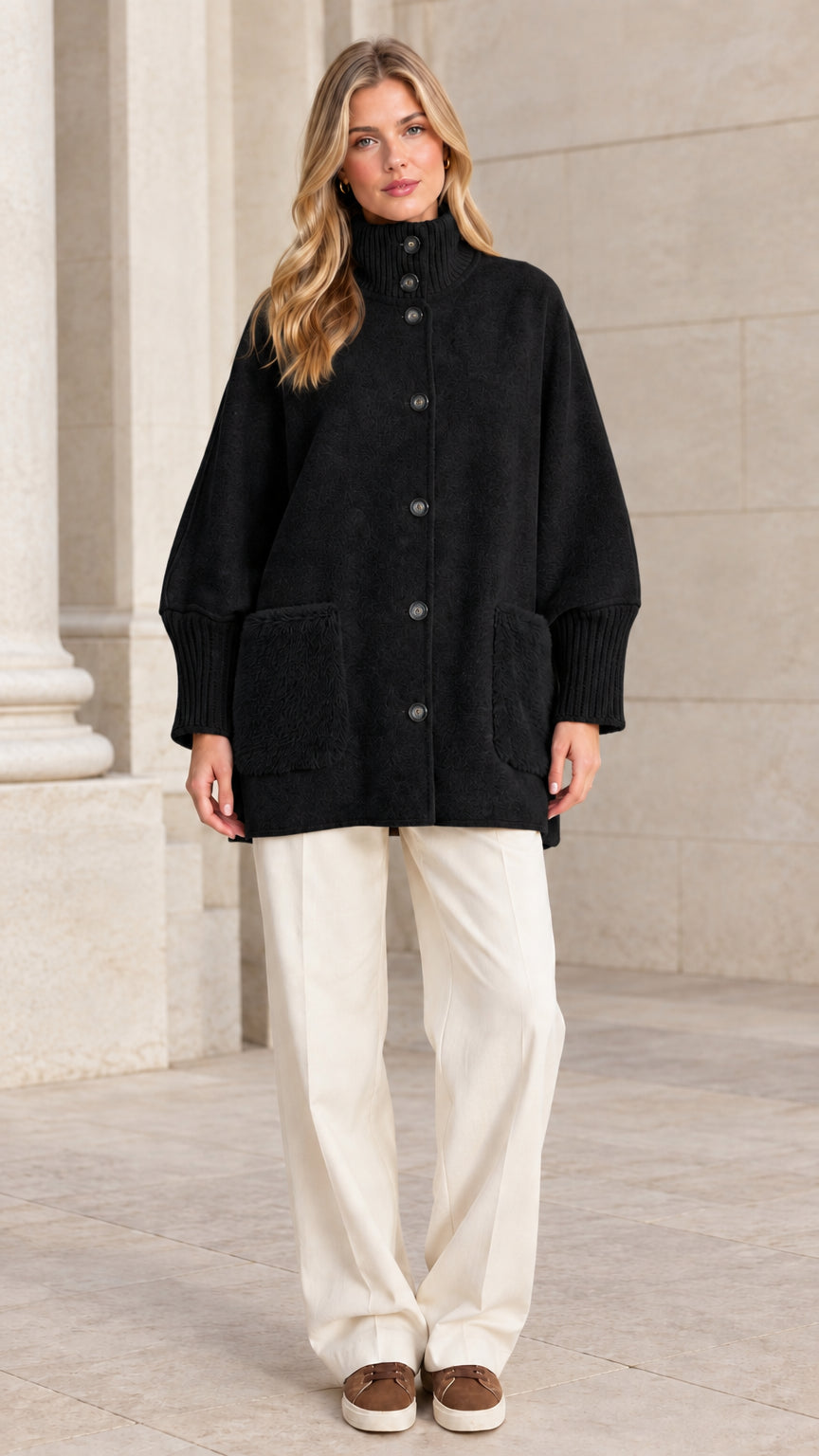 Full front view of a woman wearing a black mock neck button-down jacket