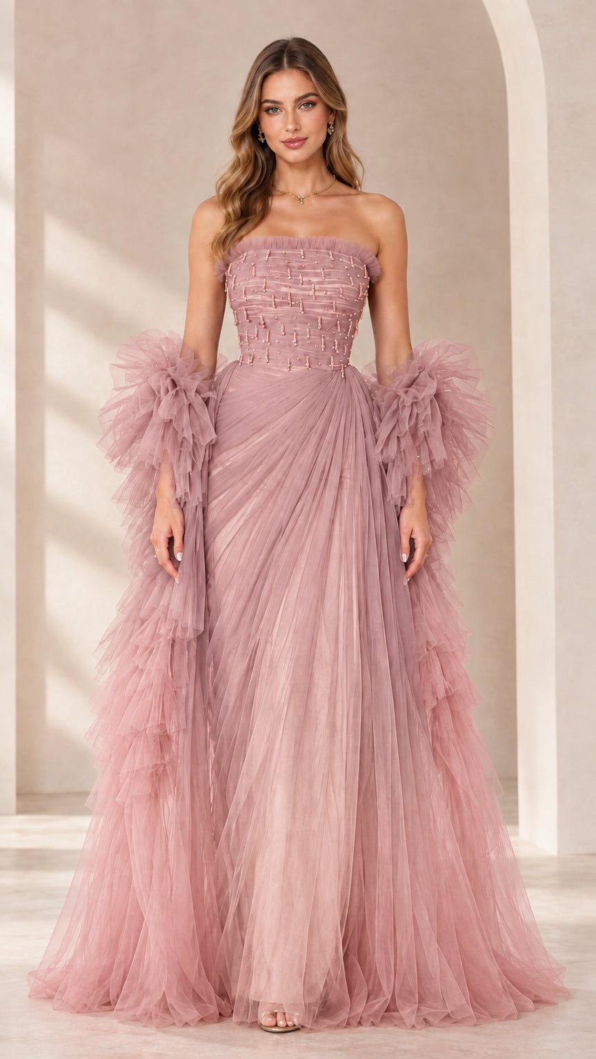 Full-length view of dusty pink strapless beaded tulle evening gown with ruffled sleeve wraps