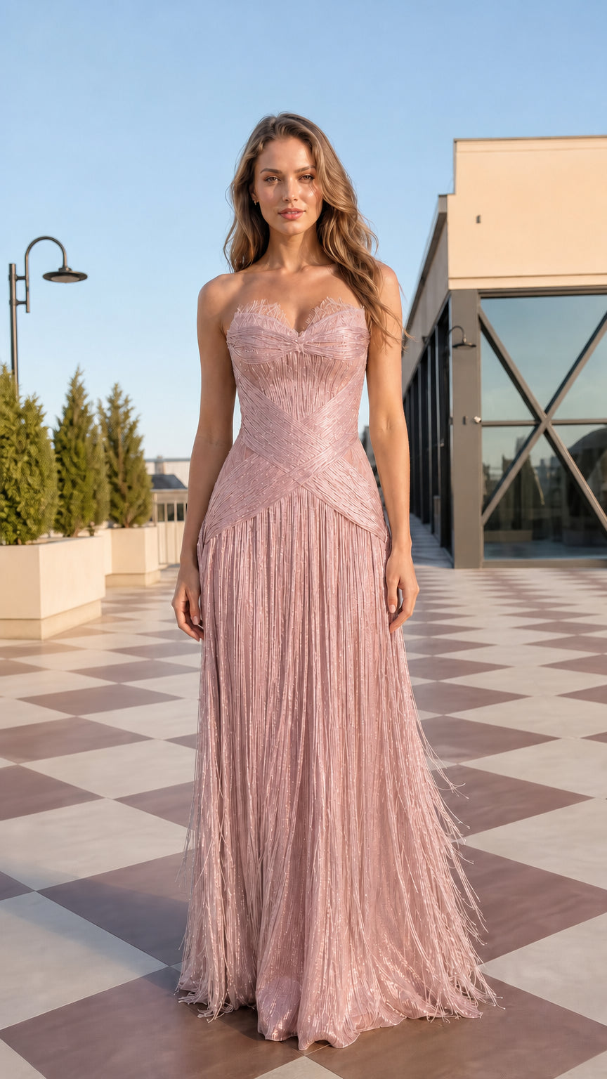 Front view of model wearing blush pink strapless sweetheart fringe maxi dress