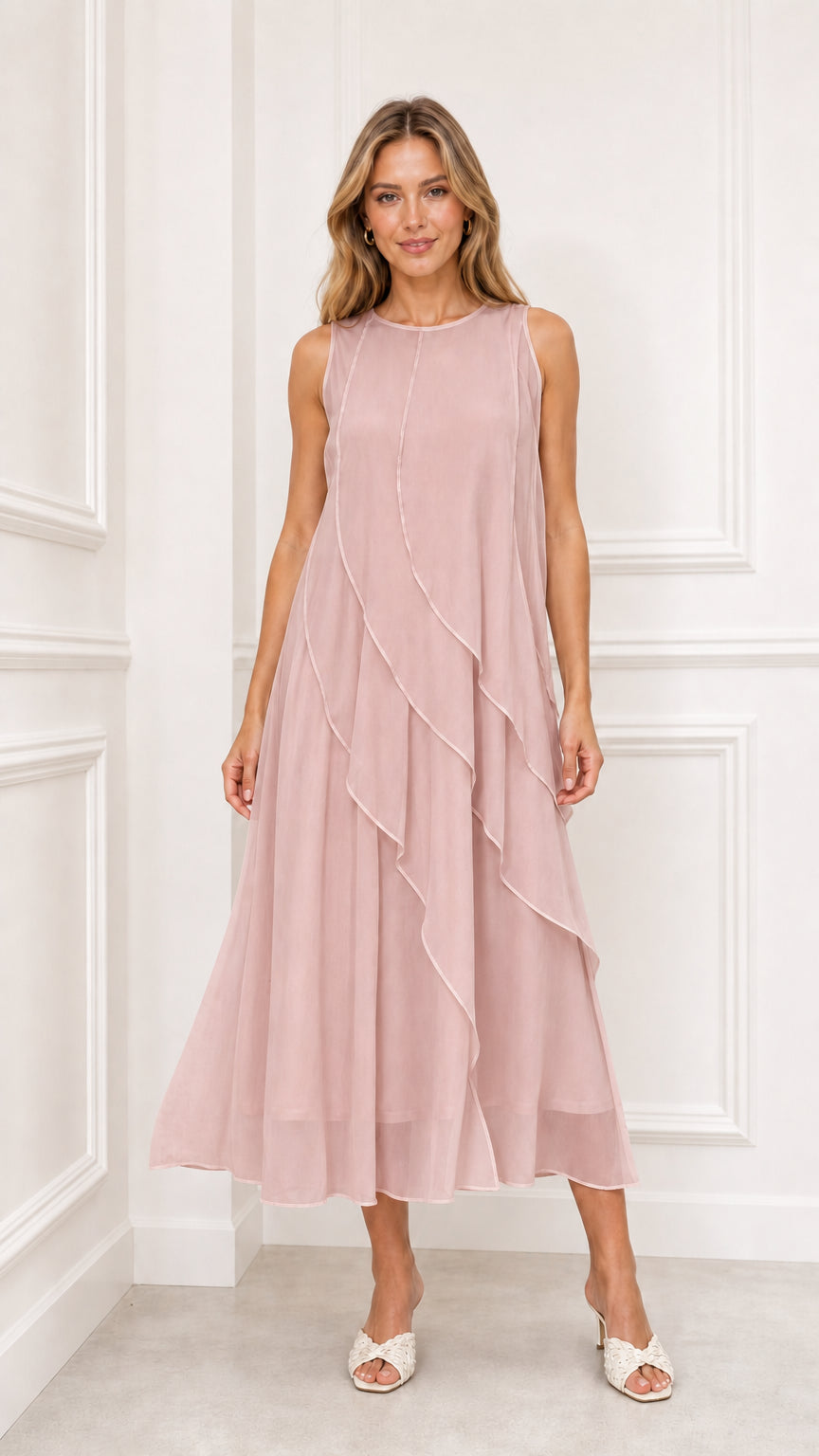 Model wearing dusty pink sleeveless cascading ruffle midi dress