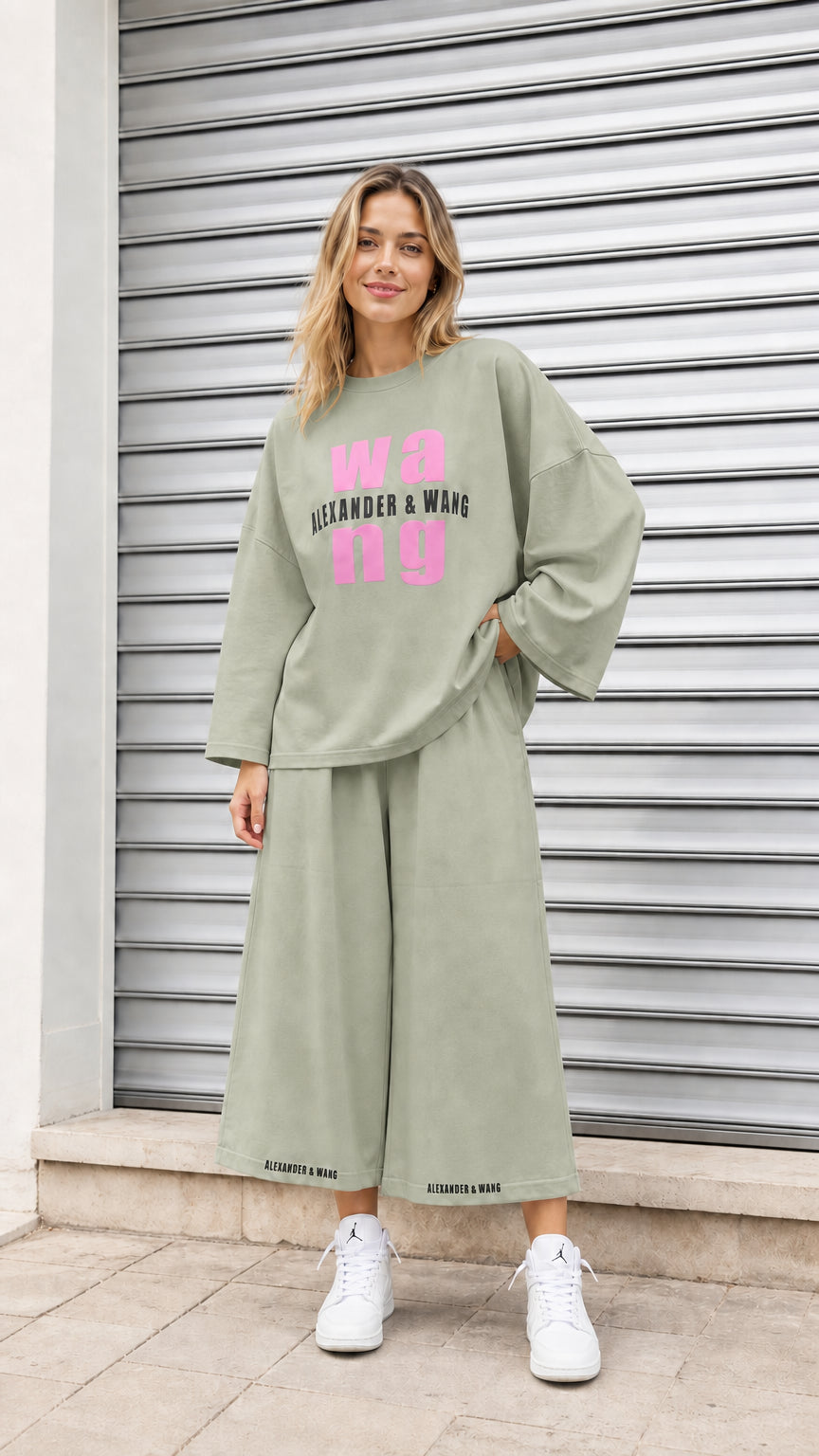 Model wearing sage green oversized graphic sweatshirt and culotte pant set