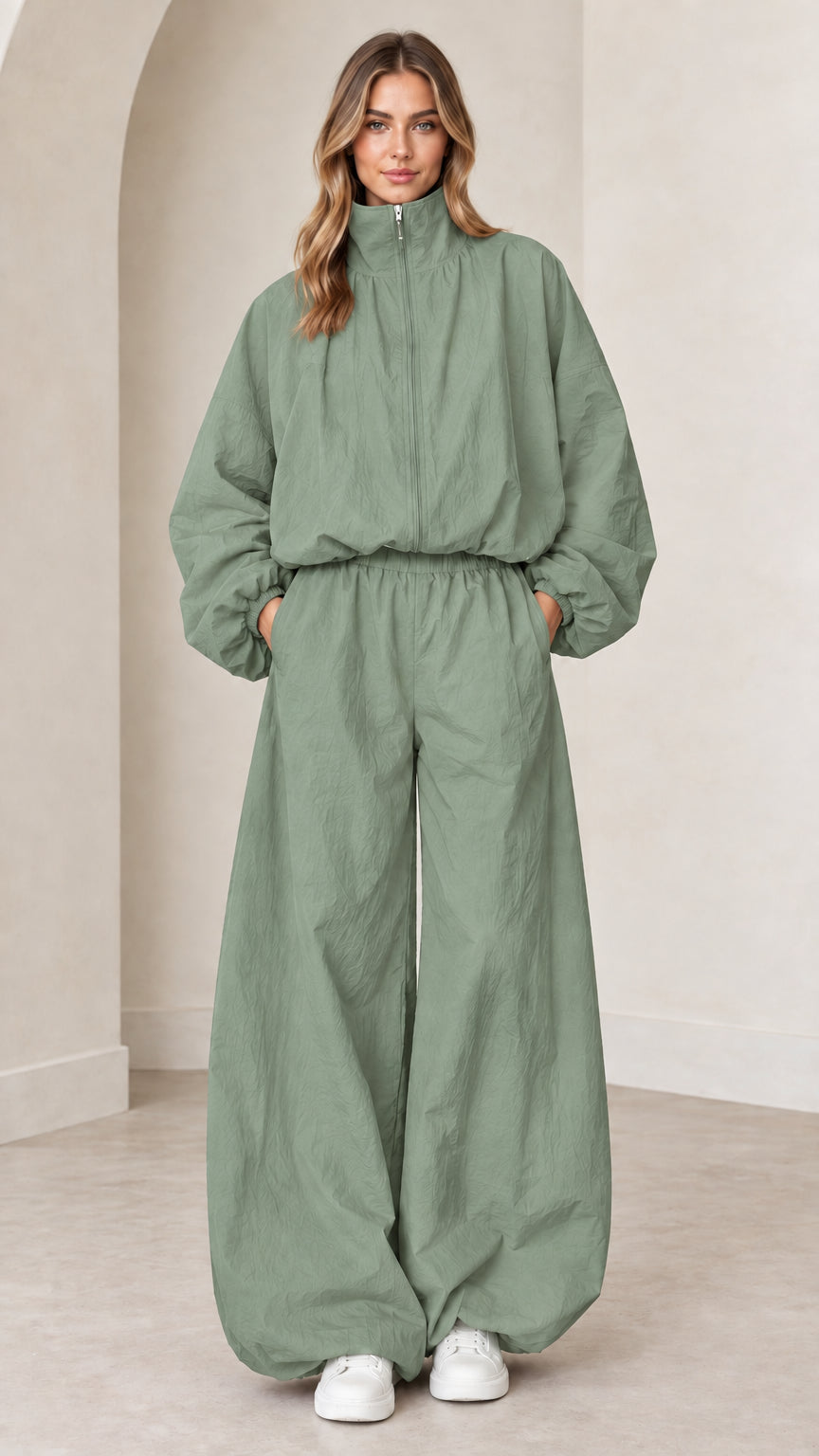 Model wearing sage green funnel neck parachute tracksuit jumpsuit