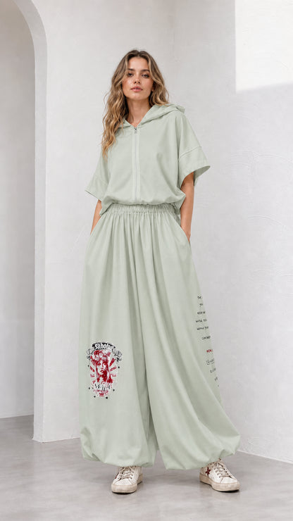 Model wearing sage green short-sleeve hooded top and relaxed wide-leg pants set