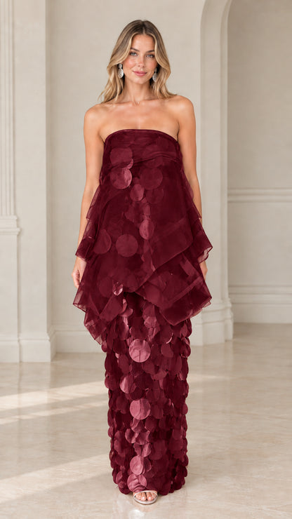 Front view of model wearing burgundy strapless tiered organza paillette maxi dress