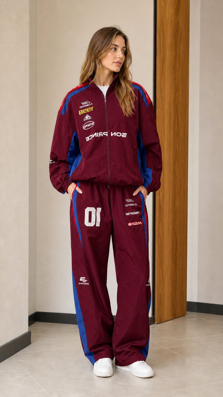 Front view of woman wearing burgundy colorblock racing two-piece tracksuit set