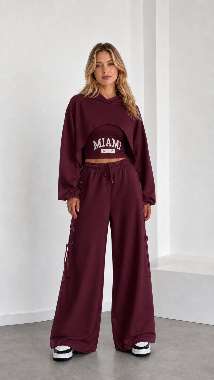 Model wearing burgundy 3-piece cropped hoodie and wide leg sweatpants set