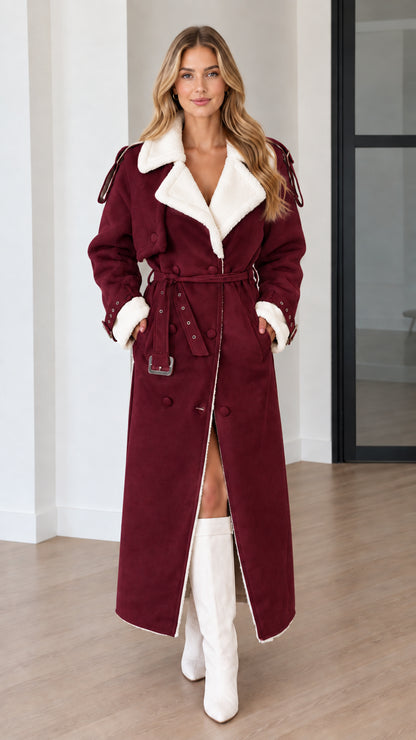 Model wearing a burgundy faux shearling lined belted maxi trench coat