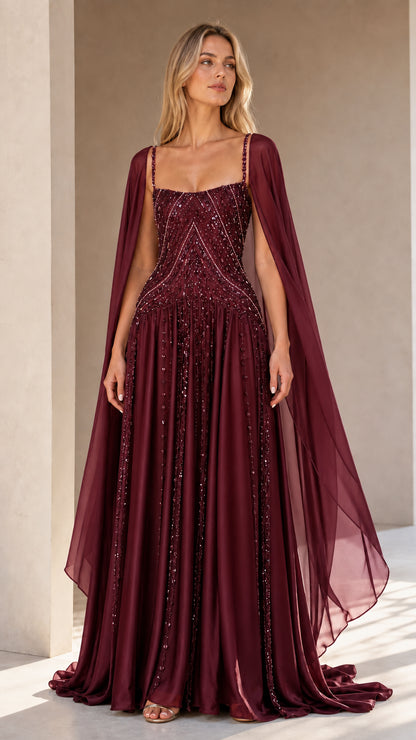 Front view of burgundy red beaded A-line cape evening dress