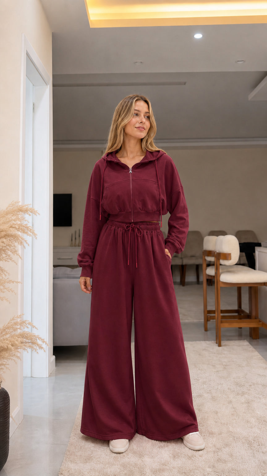 Model wearing burgundy red cropped zip hoodie and wide-leg sweatpants set