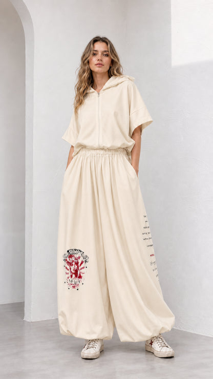 Model wearing cream beige short-sleeve hooded top and wide-leg graphic pants set